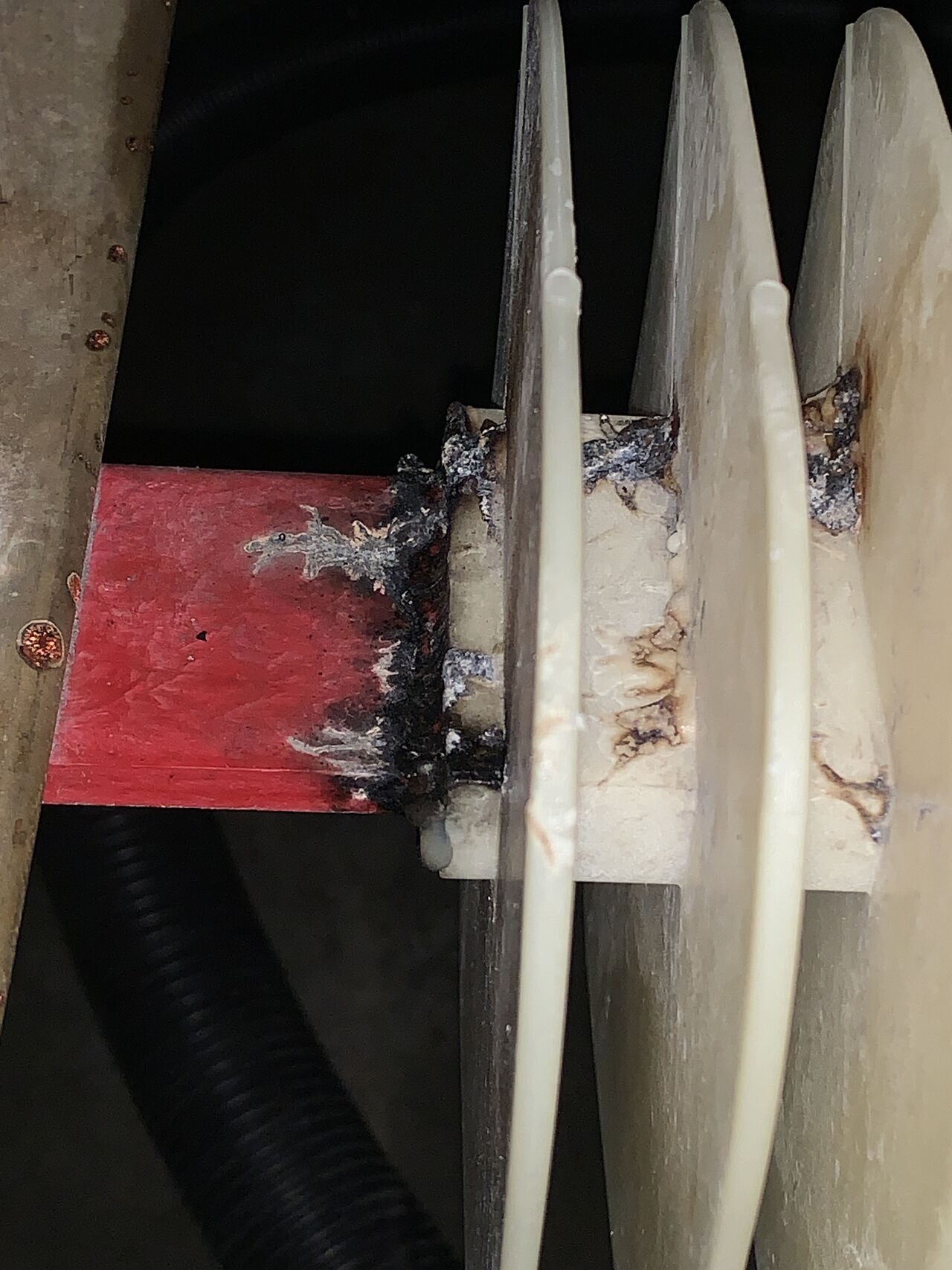 Carbonised electrical tracking spread across a busbar support and insulation barriers inside opened switchgear